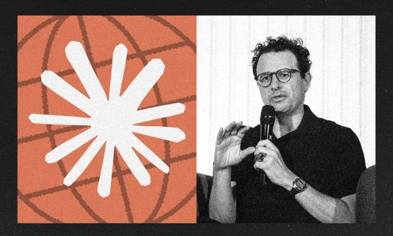Man with glasses speaking into a microphone next to a globe graphic.