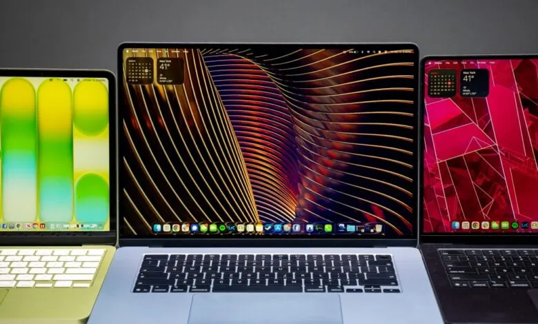 Three Apple MacBooks with different colored cases and screen wallpapers.