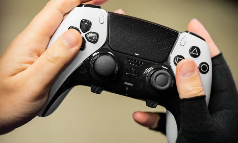 Hands holding a white and black DualSense Edge PlayStation 5 controller.
