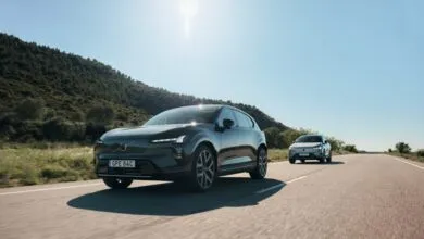Two Volvo EX30 electric SUVs driving on a sunny road.