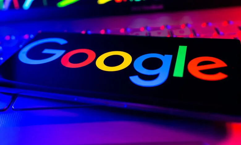 Google logo displayed on a phone screen resting on a laptop keyboard.