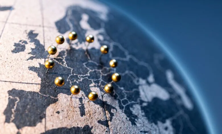 Globe map of Europe with golden pins forming EU flag stars.