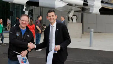 Chris Sembroski and Jared Isaacman shake hands at ribbon cutting.
