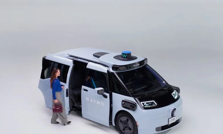 Woman exiting a light blue Waymo self-driving minivan with open door.