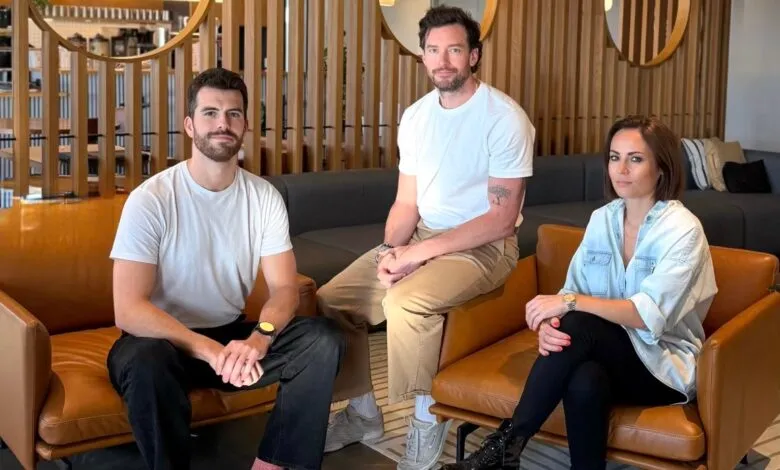 Three people sit in modern chairs in a stylish office space.