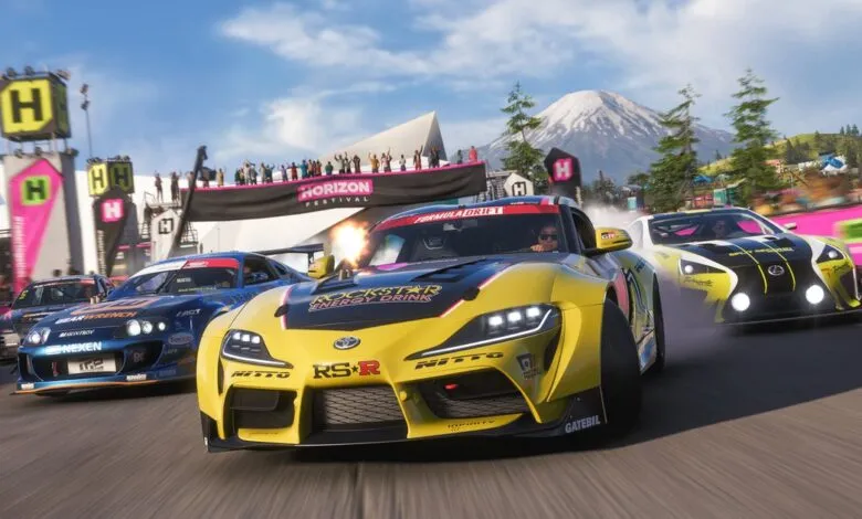 Racing cars drift at Horizon Festival, mountain backdrop, cheering crowd.
