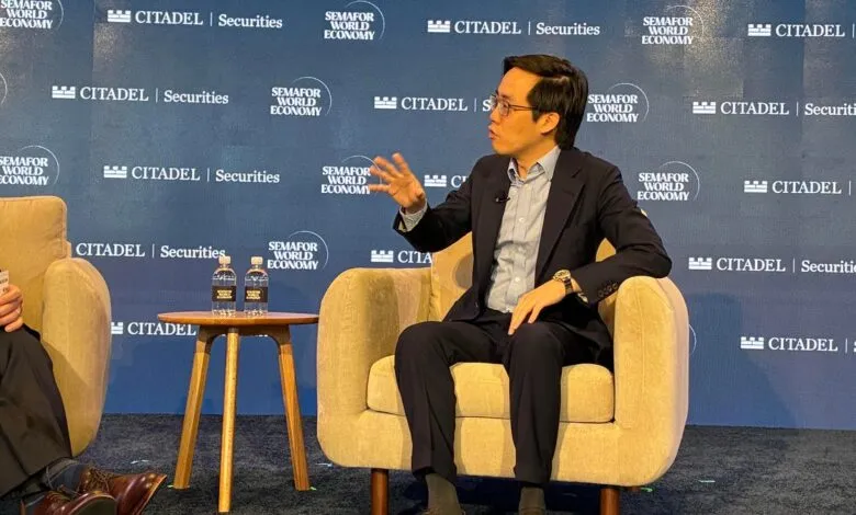 Man in suit gestures while seated at a Semafor World Economy event.