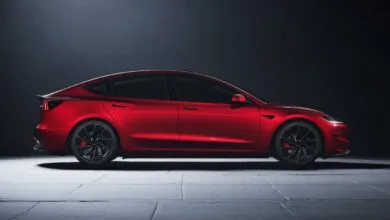 Side view of a red Tesla Model 3 Performance with black wheels.