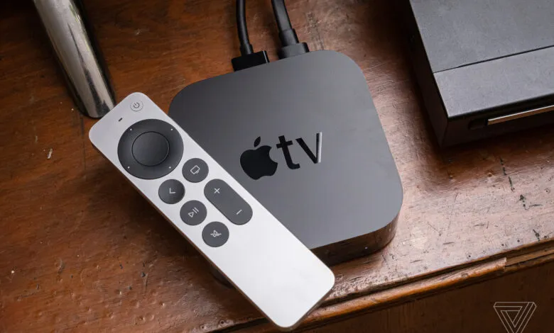 Apple TV box and silver Siri remote resting on a rustic wooden surface