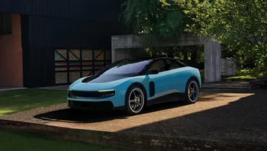 Light blue Ferrari sports car parked outside modern home.