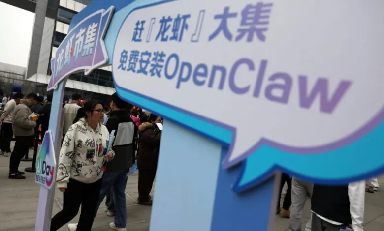 People walking past a blue sign promoting OpenClaw outside Baidu offices in Beijing