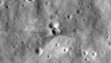 Black and white close-up of a crater on the Moon's surface with ejecta rays