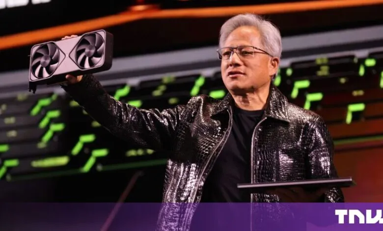 NVIDIA CEO Jensen Huang holds up a graphics card on stage during a keynote presentation.