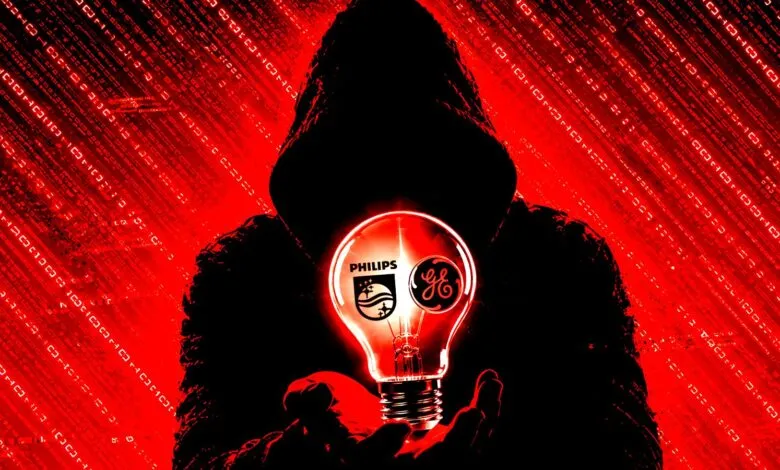 Hooded figure holding a glowing lightbulb featuring Philips and GE logos against a red binary background.