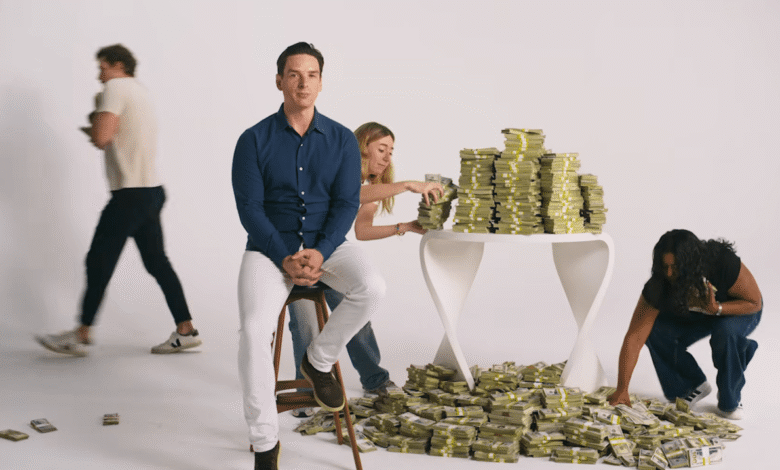 Parker Conrad seated calmly amidst stacks of cash and coworkers handling money