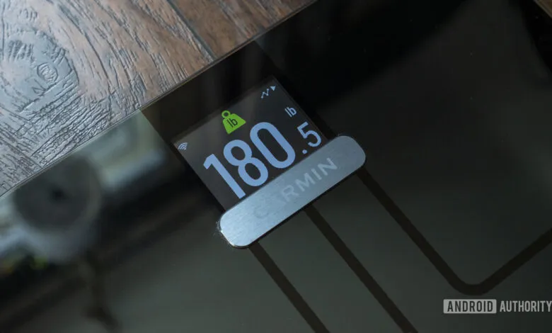 Garmin Index S2 Smart Scale displaying a weight measurement of 180.5 pounds on its color screen.