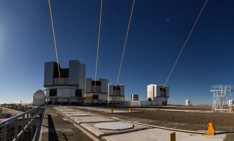 Four powerful orange lasers shoot into the night sky from telescopes at ESO's Paranal Observatory.