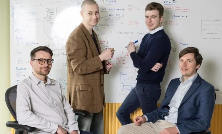Four male co-founders of Inherent Labs pose in front of a whiteboard covered in notes.