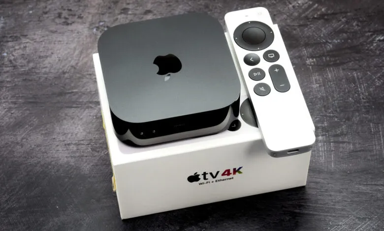 Apple TV 4K streaming device and remote resting on top of its product box