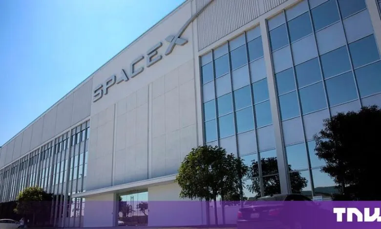 Exterior view of the modern white SpaceX headquarters building under a bright blue sky.