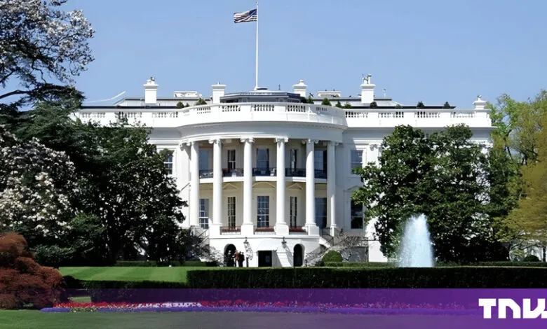 The White House exterior featuring white neoclassical architecture, towering columns, and green lawns.