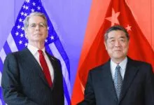 US Treasury Secretary and Chinese Vice Premier posing in front of their respective national flags