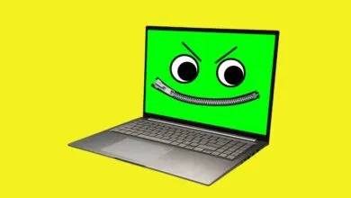 A modern laptop with a green screen displaying an angry face with a zipper mouth against a solid yellow background.