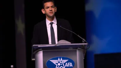 Justin Alpern speaks at a podium with an AFA logo during an official event.