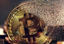 A gold bitcoin cryptocurrency dissolving into small digital triangles against a dark background.