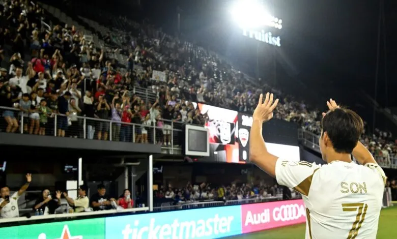 Soccer player Heung-Min Son applauding fans in stadium at night