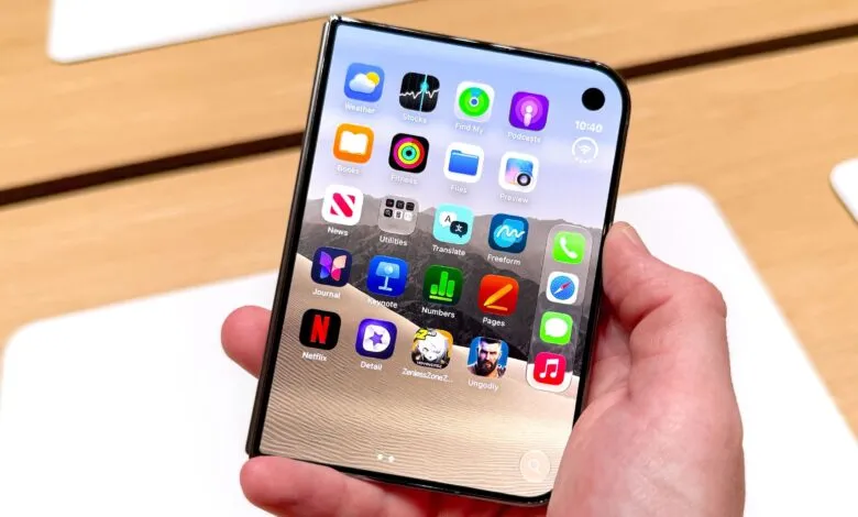 A person holds a foldable smartphone with a flexible OLED display showing colorful app icons.