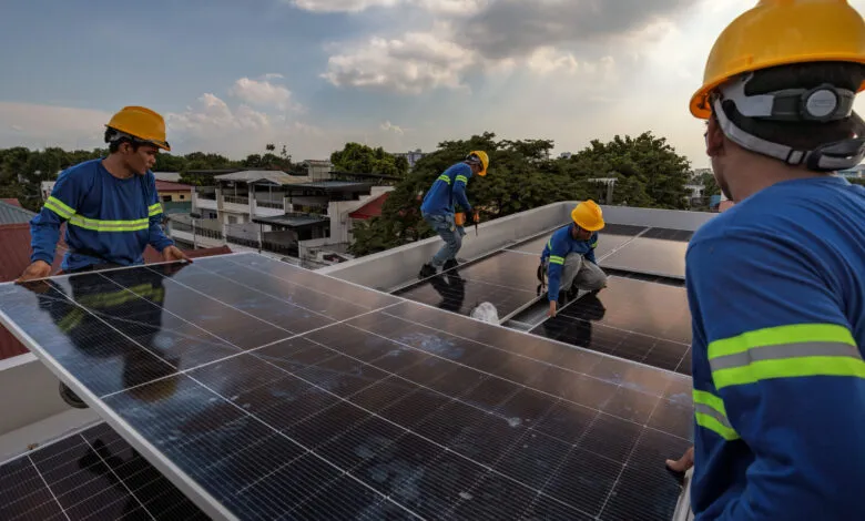 Workers install solar panels on a residential rooftop in Antipolo, Philippines, amid rising energy demand.