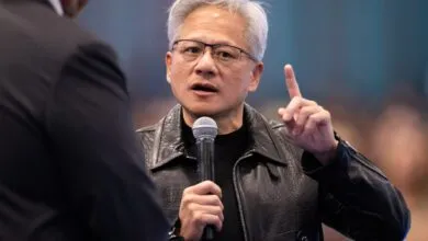 NVIDIA CEO Jensen Huang speaks into a microphone while raising a finger in discussion.