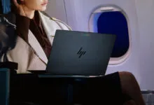 A person uses an HP laptop with a Google Chrome logo on an airplane during flight.