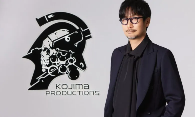 Hideo Kojima standing in front of the Kojima Productions studio logo