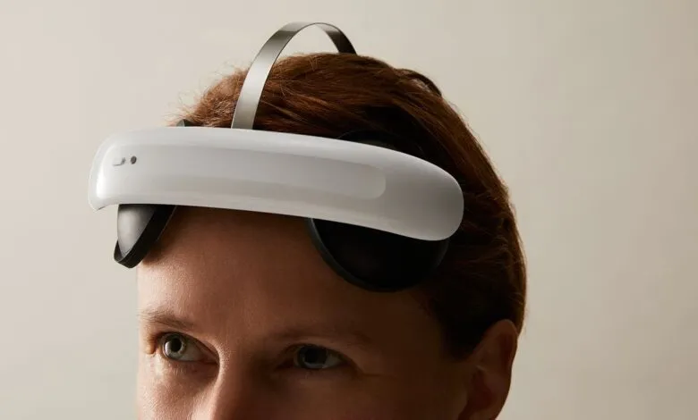 Person wearing a sleek white and black neurostimulation headset on their forehead.
