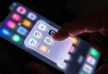 A finger interacting with an AI app folder on a smartphone screen showing ChatGPT, Gemini, and Claude.