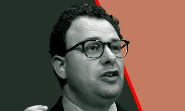 Portrait of Dario Amodei, CEO of Anthropic, wearing glasses and speaking.