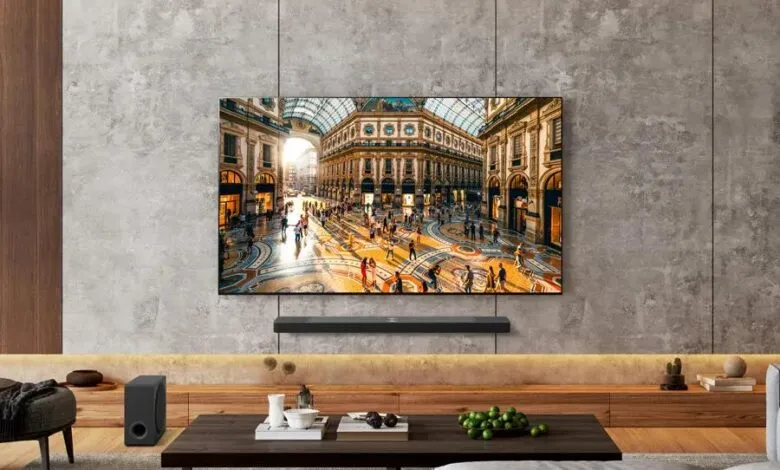 LG OLED TV mounted on a textured concrete wall displaying a vibrant Italian shopping arcade scene