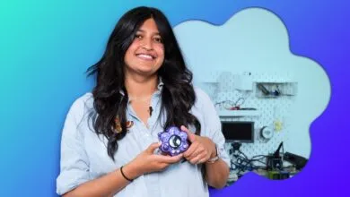 Content creator Tru Narla holds a purple custom hardware device in her workshop.
