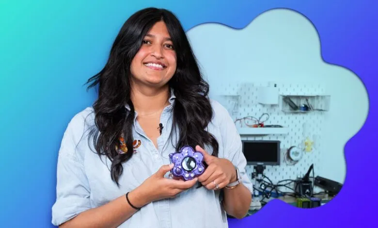Content creator Tru Narla holds a purple custom hardware device in her workshop.