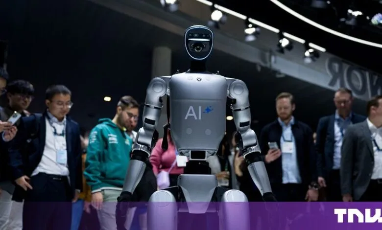A humanoid AI robot stands prominently on a convention floor, surrounded by onlookers.