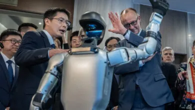 German Chancellor Friedrich Merz and Unitree Robotics founder Wang Xingxing interact with a humanoid robot.