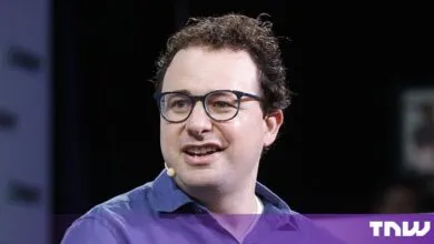 Dario Amodei, CEO of Anthropic, speaking at a conference wearing glasses and a purple shirt
