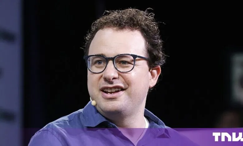 Dario Amodei, CEO of Anthropic, speaking at a conference wearing glasses and a purple shirt