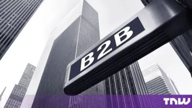 A close-up of a B2B sign against a background of towering skyscrapers.