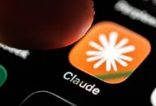 A finger approaches the orange Claude AI app icon on a smartphone home screen.