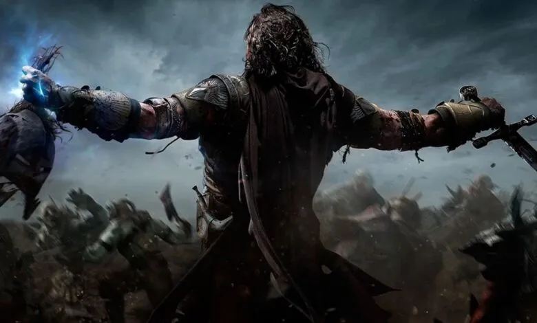 Talion holding a glowing head and a sword amidst a battlefield in Shadow of Mordor