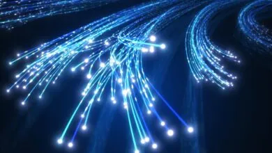 Glowing blue fiber optic cables transmitting high-speed data across a dark background.