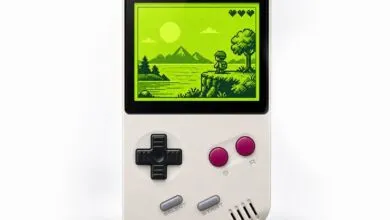 Close-up of a retro handheld gaming console displaying a pixelated landscape on a green screen.